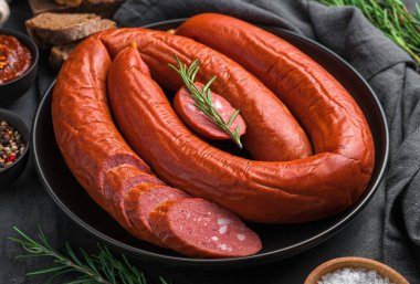 Krakow sosisi koyu bir arka planda baharat ve sosla dilimlenmiş..