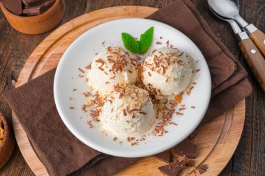 Tahta arka planda çikolata parçalı kremalı dondurma. Yan görünüm, yakın plan.