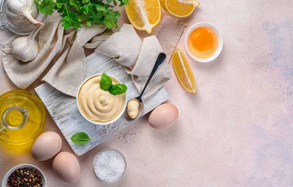 Ev yapımı mayonez ve açık pembe arka planda baharatlı malzemeler..