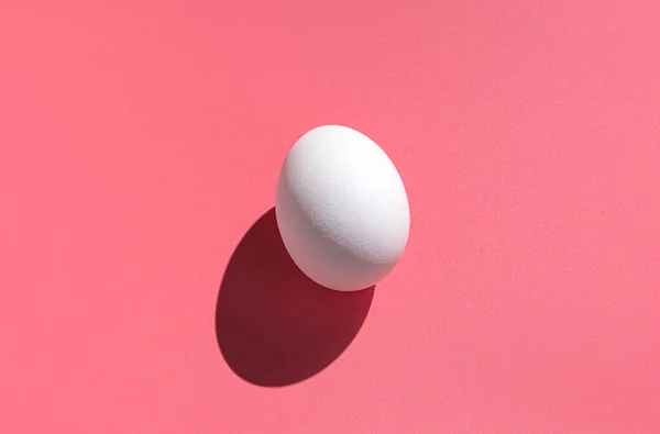 Białe Jajko Różowym Tle Twardym Cieniem Minimalistyczne Odżywianie Streszczenie Kontekstu — Zdjęcie stockowe