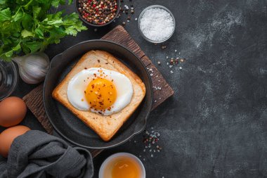Kızarmış ekmek üzerine kızarmış yumurta ve siyah bir arka plan. Üst görünüm, alanı kopyala.