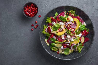Peynirli sebze salatası, nar, fındık, keten ve susam tohumu. Avokado ve salatalıklı vitamin salatası. Üst görünüm, alanı kopyala.