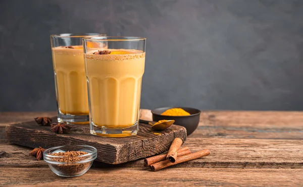 Healthy coffee drink with turmeric and cinnamon on a wooden background. Royalty Free Stock Images