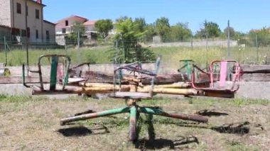 old rusty carousel for kids in rural garden