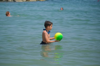 Güzel çocuk Rimini denizinde top oynuyor. Yüksek kalite fotoğraf