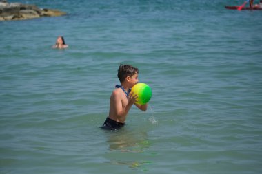 Güzel çocuk Rimini denizinde top oynuyor. Yüksek kalite fotoğraf