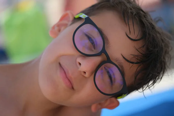 beautiful face portrait of Italian child with glasses and wet hair from the sea. High quality photo