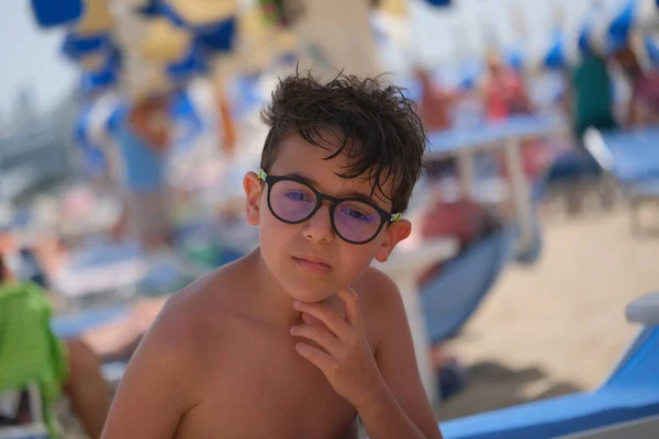 beautiful face portrait of Italian child with glasses and wet hair from the sea. High quality photo