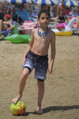 Güzel İtalyan çocuk yüzme kıyafeti ve gözlükleriyle sahilde poz veriyor. Yüksek kalite fotoğraf