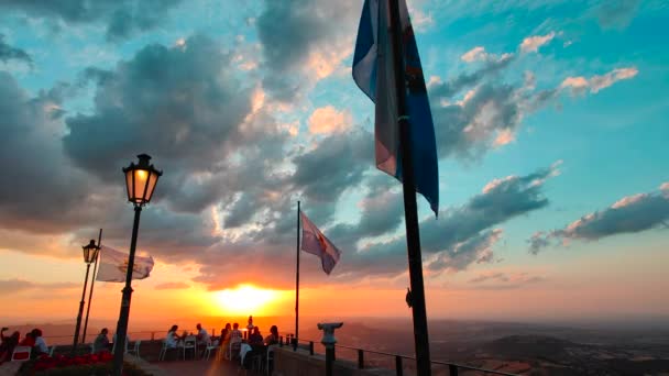 Flags of the republic of San Marino on Mount Titano wave at sunset — Stock Video