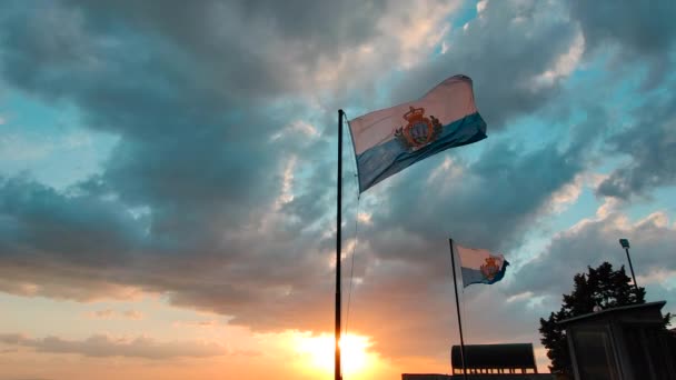 San Marino cumhuriyetinin bayrakları Titano dağında gün batımında dalgalanıyor. — Stok video