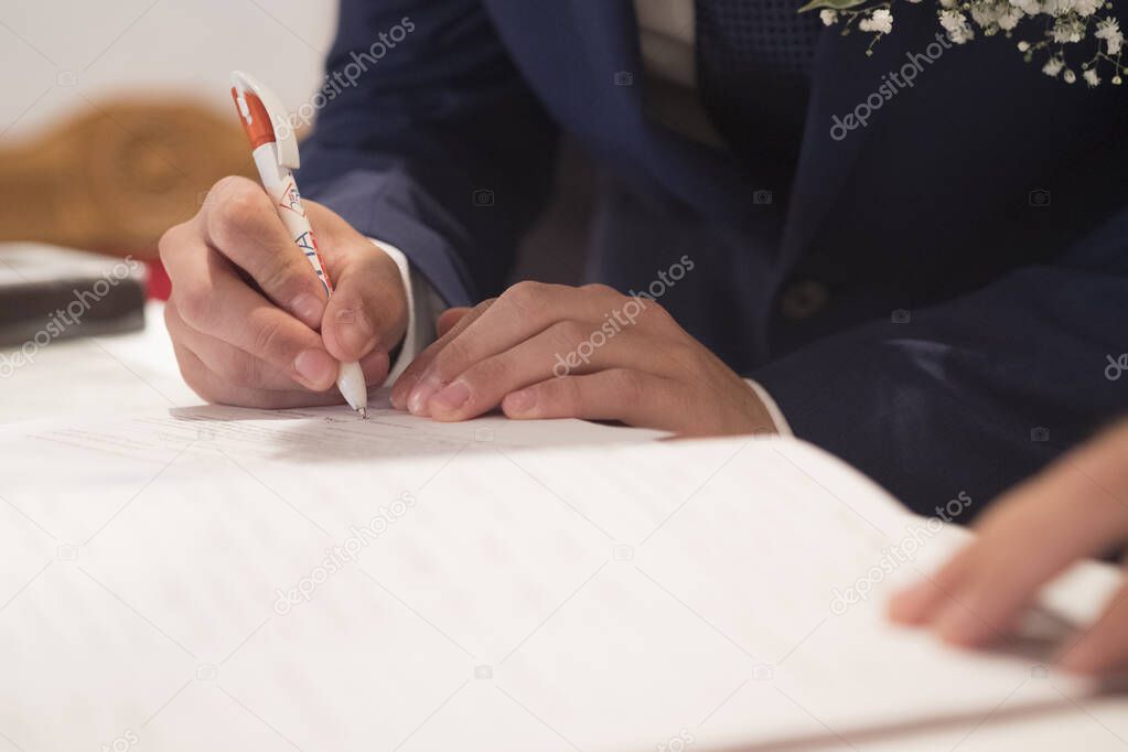 wedding best man groom signing register in catholic wedding. High quality photo