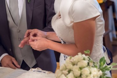 Gelin, İtalya 'daki Katolik ayininde damada nikah yüzüğü takıyor. Yüksek kalite fotoğraf