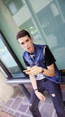 Kot ceketli yakışıklı çocuk akıllı telefon kullanıyor, yüksek kalite fotoğraf.