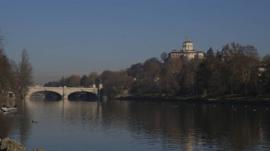 Torino 'daki Po nehri üzerindeki köprü Valentino parkından ve arka planda Monte dei Cappuccini' den görülüyor. Yüksek kalite fotoğraf