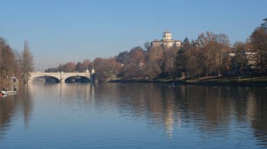 Torino 'daki Po nehri üzerindeki köprü Valentino parkından ve arka planda Monte dei Cappuccini' den görülüyor. Yüksek kalite fotoğraf