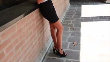 Güzel esmer kız dışarıda mini etekli tablet kullanıyor.