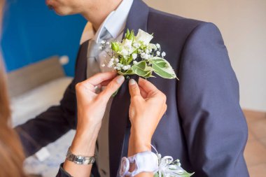 Abla damadın cebine küçük bir buket koyar. Yüksek kalite fotoğraf