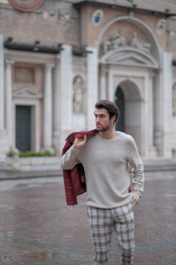 Reggio Emilia 'nın ortasında kırmızı deri ceketli ve sırt çantalı güzel bir adam. Yüksek kalite fotoğraf