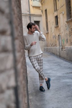 Reggio Emilia 'nın ortasında beyaz kazaklı güzel bir adam. Yüksek kalite fotoğraf