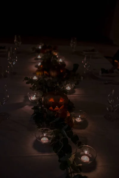 Halloween pumpkin on a table set for a gala dinner. High quality photo