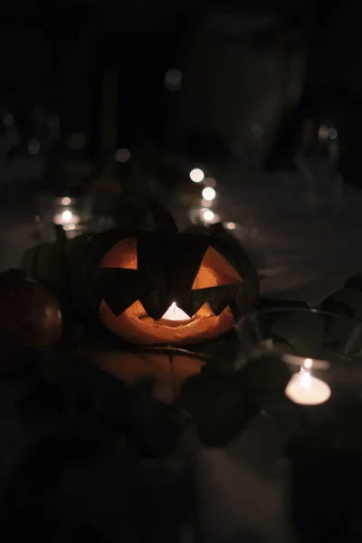 Halloween pumpkin on a table set for a gala dinner. High quality photo