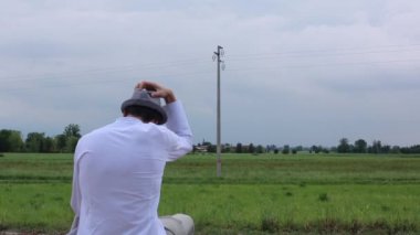 Tren rayları boyunca şapkalı bir adam başarısız iş kaybı yaşıyor.