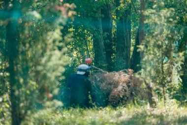 Orman manzaralı ormanda paintball oyuncusu maske ve işaret takarak oyun kuruyor. Yüksek kalite fotoğraf