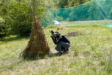 Orman manzaralı ormanda paintball oyuncusu maske ve işaret takarak oyun kuruyor. Yüksek kalite fotoğraf