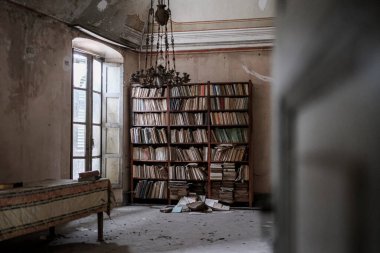 Büyük terk edilmiş evdeki oturma odasında büyük bir kütüphane. Yüksek kalite fotoğraf