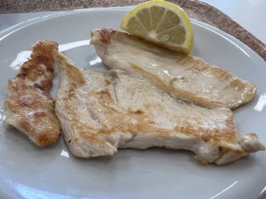 Beyaz tabakta limonlu domuz pirzolası. Yüksek kalite fotoğraf