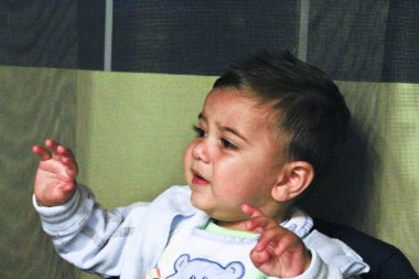 Güzel bebek içkileri ve yüksek sandalyede yemek yiyor. Yüksek kalite fotoğraf