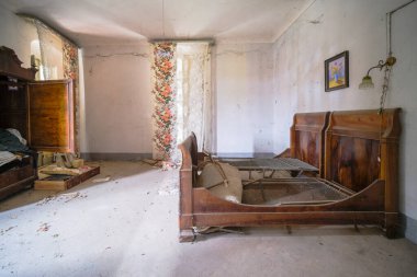 Terk edilmiş büyük bir villada ahşap yataklı bir yatak odası. Yüksek kalite fotoğraf