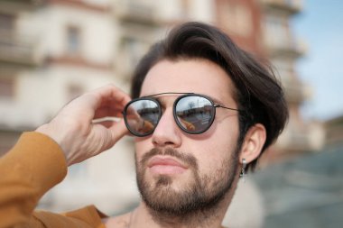 Güzel, siyah saçlı, aynalı güneş gözlüklü bir İtalyan. Yüksek kalite fotoğraf