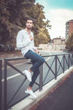 Akıllı telefondaki güzel, siyah saçlı İtalyan adam. Yüksek kalite fotoğraf