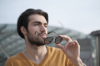 Güzel, siyah saçlı, aynalı güneş gözlüklü bir İtalyan. Yüksek kalite fotoğraf