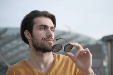 Güzel, siyah saçlı, aynalı güneş gözlüklü bir İtalyan. Yüksek kalite fotoğraf