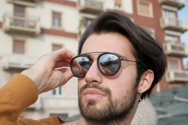 Güzel, siyah saçlı, aynalı güneş gözlüklü bir İtalyan. Yüksek kalite fotoğraf