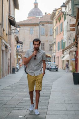 Güzel, siyah saçlı İtalyan çocuk tarihi İtalyan kasabasında geziniyor. Yüksek kalite fotoğraf