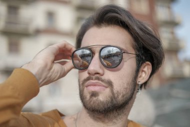 Güzel, siyah saçlı, aynalı güneş gözlüklü bir İtalyan. Yüksek kalite fotoğraf