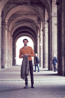 Parma 'nın ortasında, Pilotta' nın kemerlerinin altında ceketi olan zarif, siyah saçlı İtalyan bir çocuk. Yüksek kalite fotoğraf