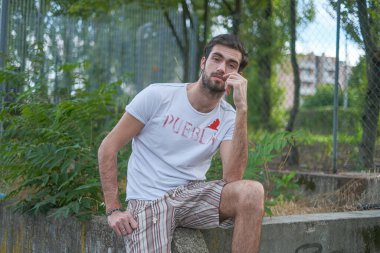 Tuğla duvara yaslanmış siyah saçlı güzel bir çocuk. Yüksek kalite fotoğraf