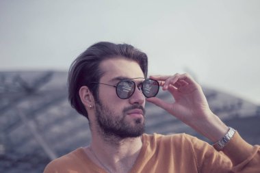 Güzel, siyah saçlı, aynalı güneş gözlüklü bir İtalyan. Yüksek kalite fotoğraf