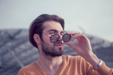 Güzel, siyah saçlı, aynalı güneş gözlüklü bir İtalyan. Yüksek kalite fotoğraf