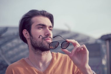 Güzel, siyah saçlı, aynalı güneş gözlüklü bir İtalyan. Yüksek kalite fotoğraf