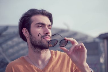 Güzel, siyah saçlı, aynalı güneş gözlüklü bir İtalyan. Yüksek kalite fotoğraf