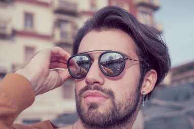 Güzel, siyah saçlı, aynalı güneş gözlüklü bir İtalyan. Yüksek kalite fotoğraf