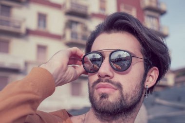 Güzel, siyah saçlı, aynalı güneş gözlüklü bir İtalyan. Yüksek kalite fotoğraf