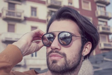 Güzel, siyah saçlı, aynalı güneş gözlüklü bir İtalyan. Yüksek kalite fotoğraf
