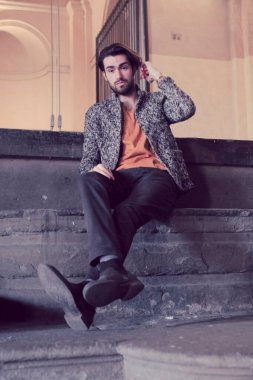 Parma 'nın ortasında, Pilotta' nın merdivenlerinde ceketli, zarif, siyah saçlı İtalyan çocuk. Yüksek kalite fotoğraf